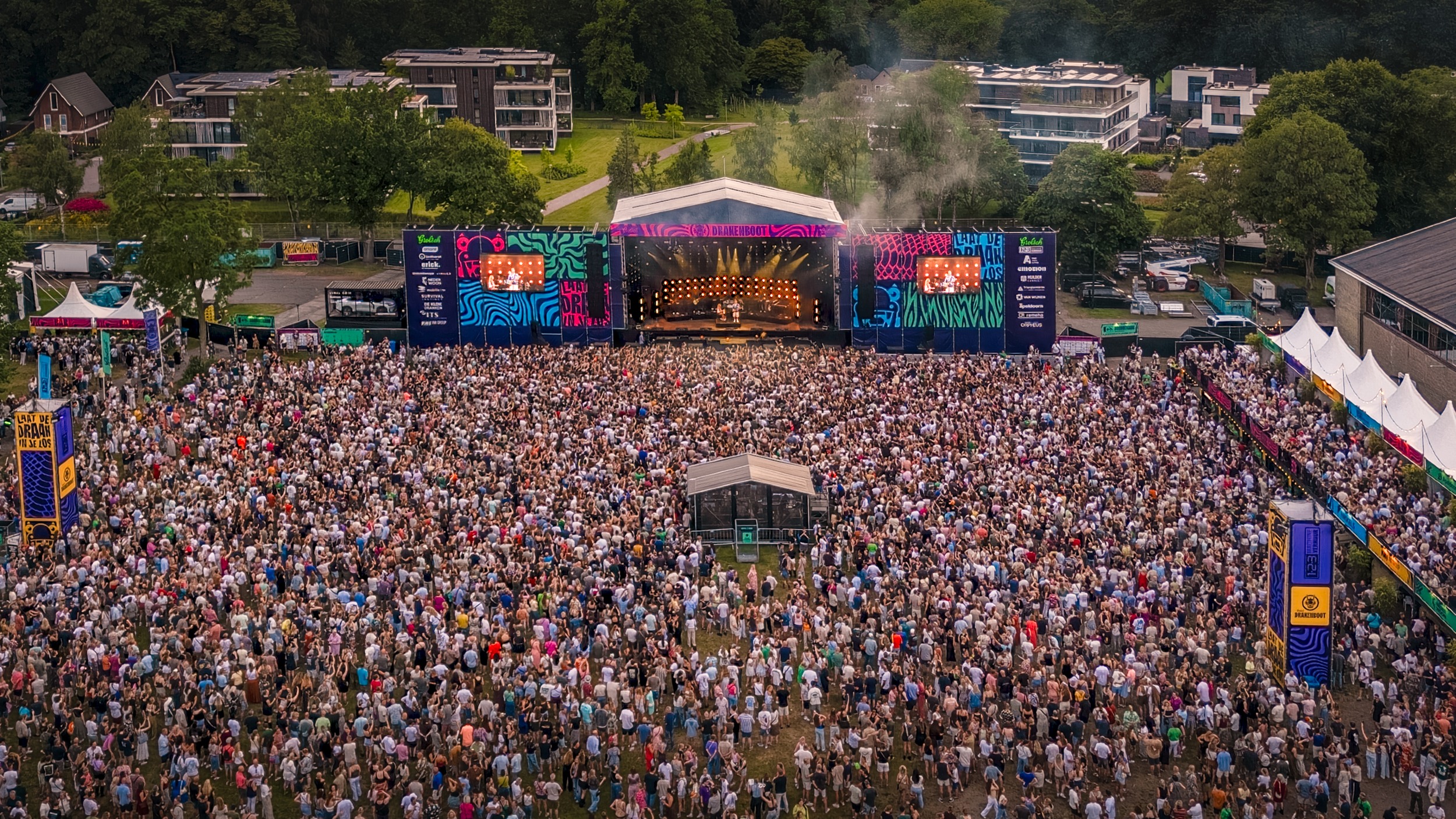 Dronefoto van het hoofdpodium en festivalpubliek tijdens het optreden van Suzan & Freek op het Grolsch Drakenbootfestival Apeldoorn 2026